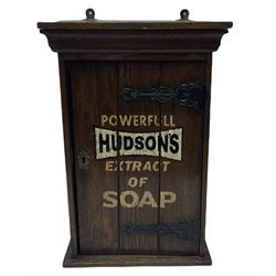 Wall mounted Hudson's display cabinet with projecting cornice, the main central door decorated with 'Powerful Hudson's Extract of Soap' lettering enclosing interior with fitted shelf, the door with Arts and Crafts style hinges with pointed heart motifs and ornate escutcheon, H46cm, W31cm, D17cm