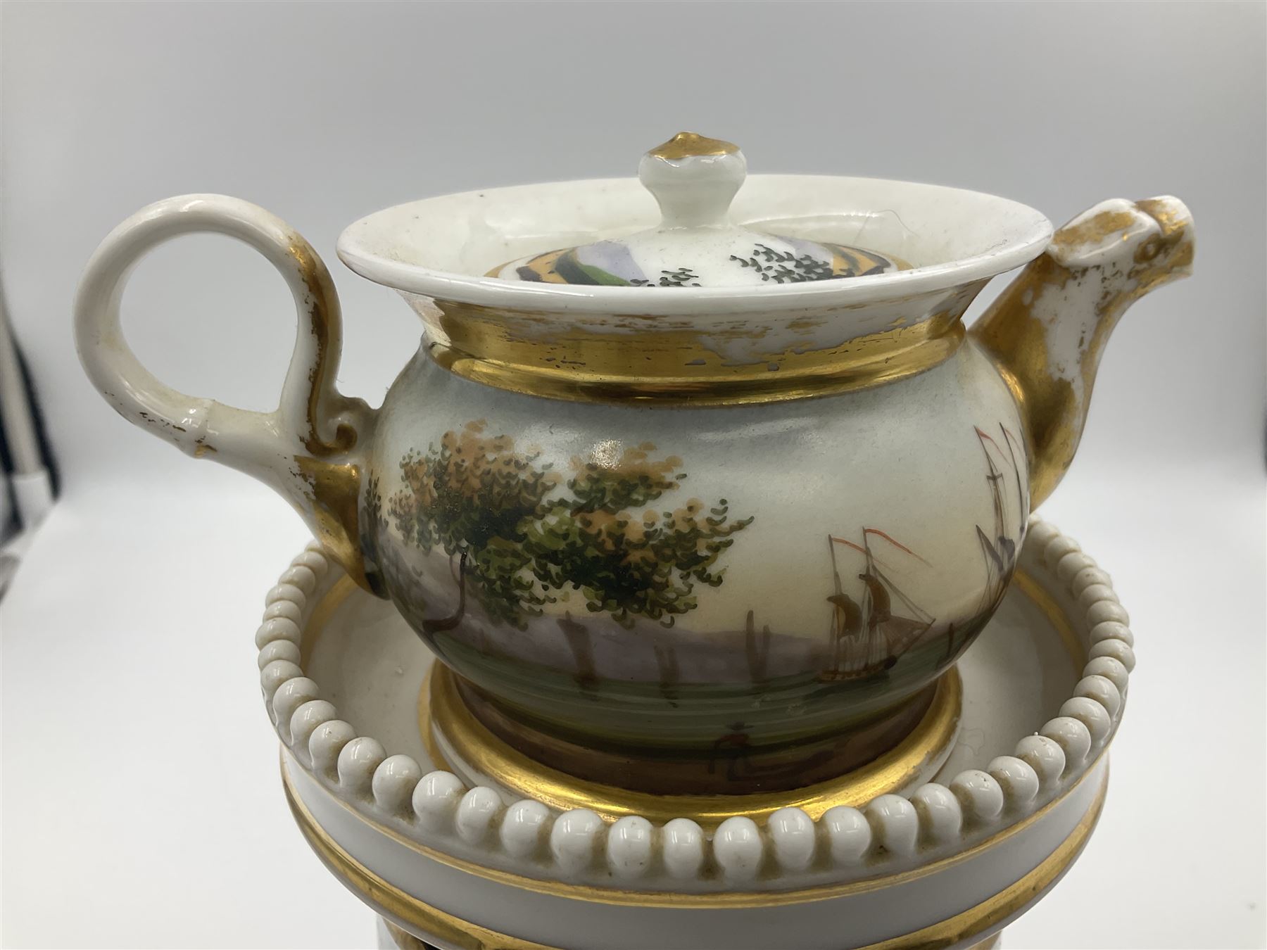 Two 19th century continental teapots and warmers, each teapot upon a cylindrical warming base, hand printed with seascapes, largest H22cm 