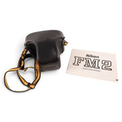 Nikon FM2 film camera body serial no. 7814849 with a Sigma 24mm lens serial no.5083190, camera user manual and Nikon carrying case
