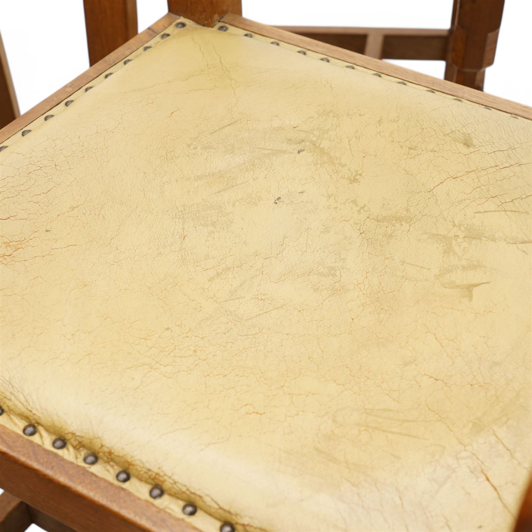 Mouseman - set of six (4+2) oak dining chairs, pierced and carved lattice back over leather upholstered seat, on octagonal front supports united by stretchers, carved with mouse signature, by the workshop of Robert Thompson, Kilburn