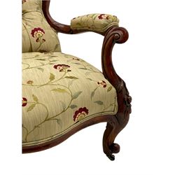Victorian walnut open armchair, the cresting rail carved with flower heads and foliate motifs, floral carved scrolling supports, upholstered in pale fabric with raised floral decoration