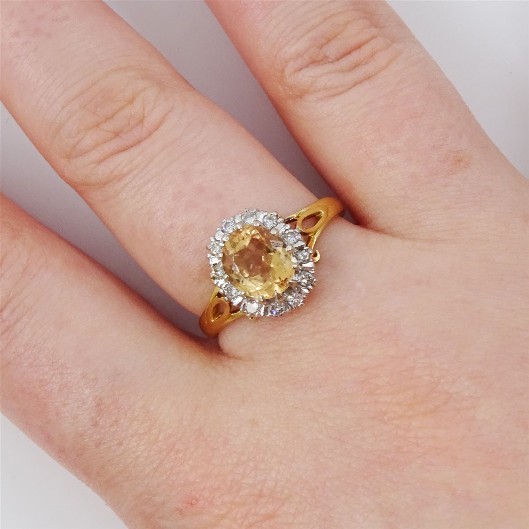 18ct gold imperial topaz and diamond cluster ring, oval cut topaz of approx 1.50 carat, surrounded by twelve round brilliant cut diamonds, London 1987, total diamond weight approx 0.10 carat