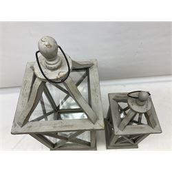 Two wooden lanterns with four glass sides, loop handles and open tops, largest example 58cm