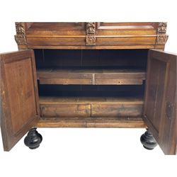 Late 17th century Flemish/Dutch rosewood and oak ‘Zeeuwse Kast’ or cupboard, projecting cornice carved with three putti masks, the uprights carved with lion masks over ribbons, flower heads and foliage, enclosed by four geometric panelled doors, lower central upright carved with flower head over foliate ribbon with bird among foliage, the escutcheon hidden by swivel berry carved cover, interior fitted with shelves, two drawers and shallow hinged cupboard, on two large turned and ebonised feet, circa 1680