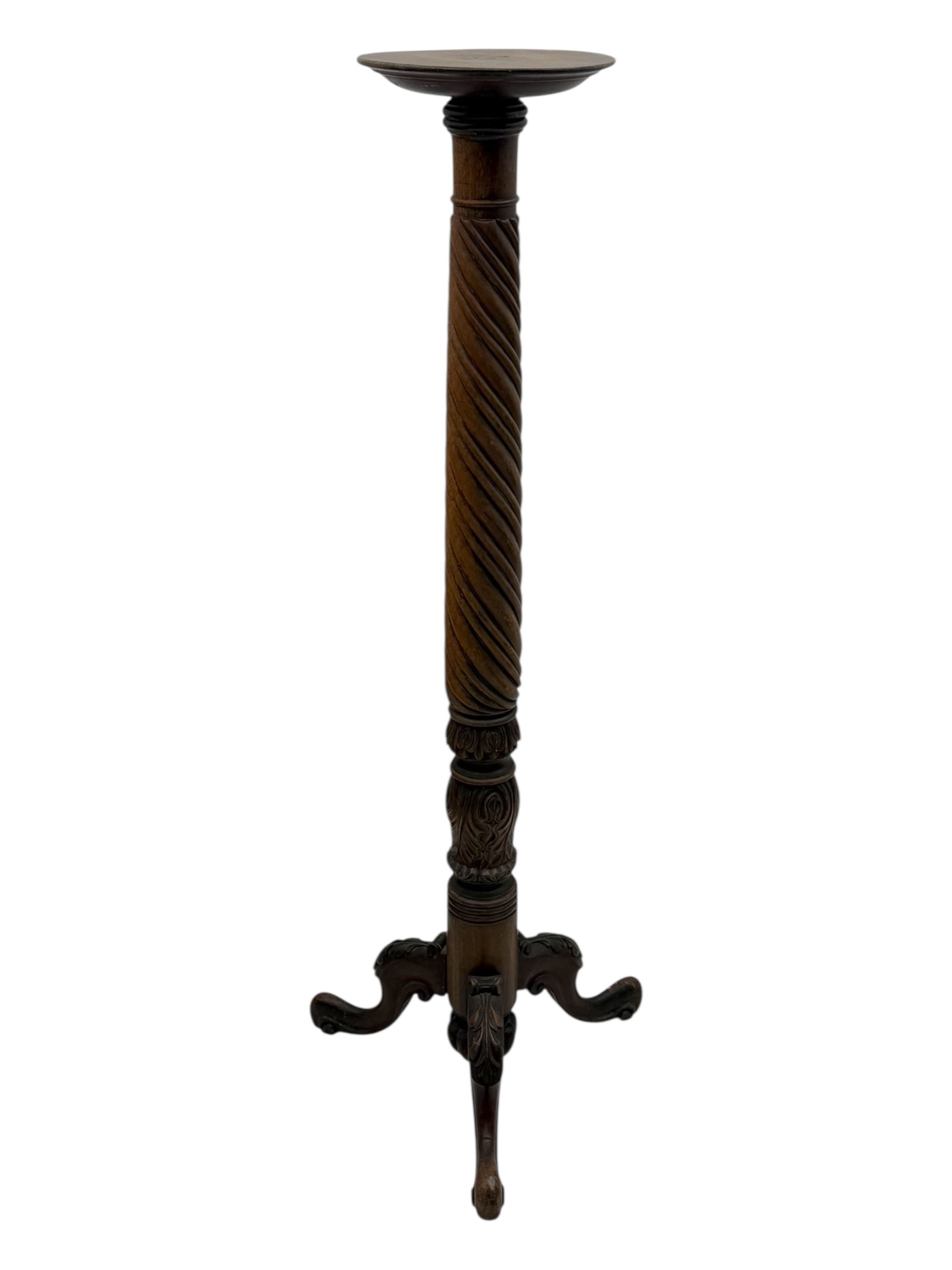 Late 19th century mahogany torchère stand, with circular top above a twisted and foliate carved collumn, on a scroll carved tripod base, on cabriole legs