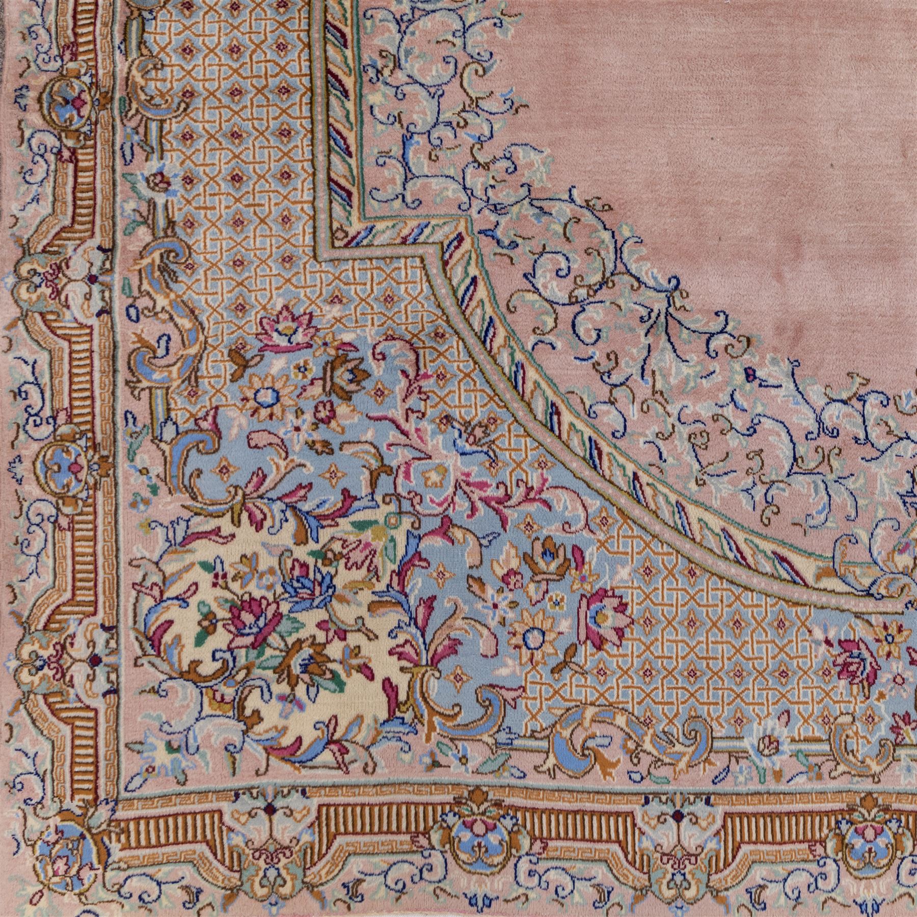 South East Persian Kirman hand-knotted rug, pale blush field with central scalloped medallion within an elaborate scalloped cartouche, spandrels filled with fine scrolling vine-work, palmettes and floral sprays, enclosed by wide and narrow borders in soft tones of blush pink, ivory, powder blue, sage green and pale gold, with cotton fringe ends 