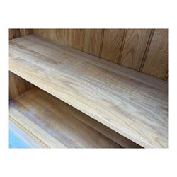 Contemporary light oak open bookcase, rectangular form with projecting top, fitted with five adjustable shelves, on a straight plinth base