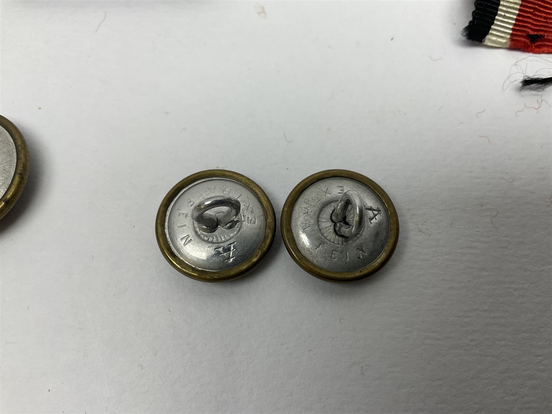 Collection of eleven German metal and cloth badges and uniform buttons including driver's badge, two 'SS' fabric skulls, private's shoulder tabs, Police cloth badge, tank destruction badge, medal bars and ribbon etc; most WW2 period