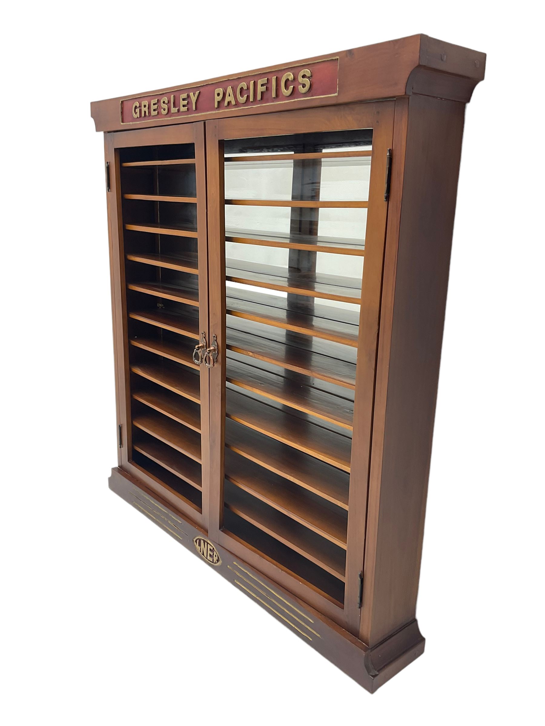 Modern hardwood display cabinet for model railway locomotives inscribed 'Gresley Pacifics' to the frieze and 'LNER' to the bottom rail; with mirrored back and ten loose fitting shelves enclosed by a pair of unglazed doors L101cm H108cm D16cm