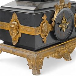 French- late 19th century 8-day mantle clock in an imposing Belgium slate case with gilt metal ornamentation. Stepped rectangular case with an angled top and square plinth surmounted by an oval shaped gilt urn with scroll handles, case with continuous strapwork and oval medallions displaying portraits from classical antiquity, raised on a gilt metal base with splayed feet, conforming unenclosed slate dial with gold incised Roman numerals and brass Fleur de Lis hands, Parisian twin train rack striking movement with pendulum regulation, striking the hours and half hours on a bell. With pendulum.