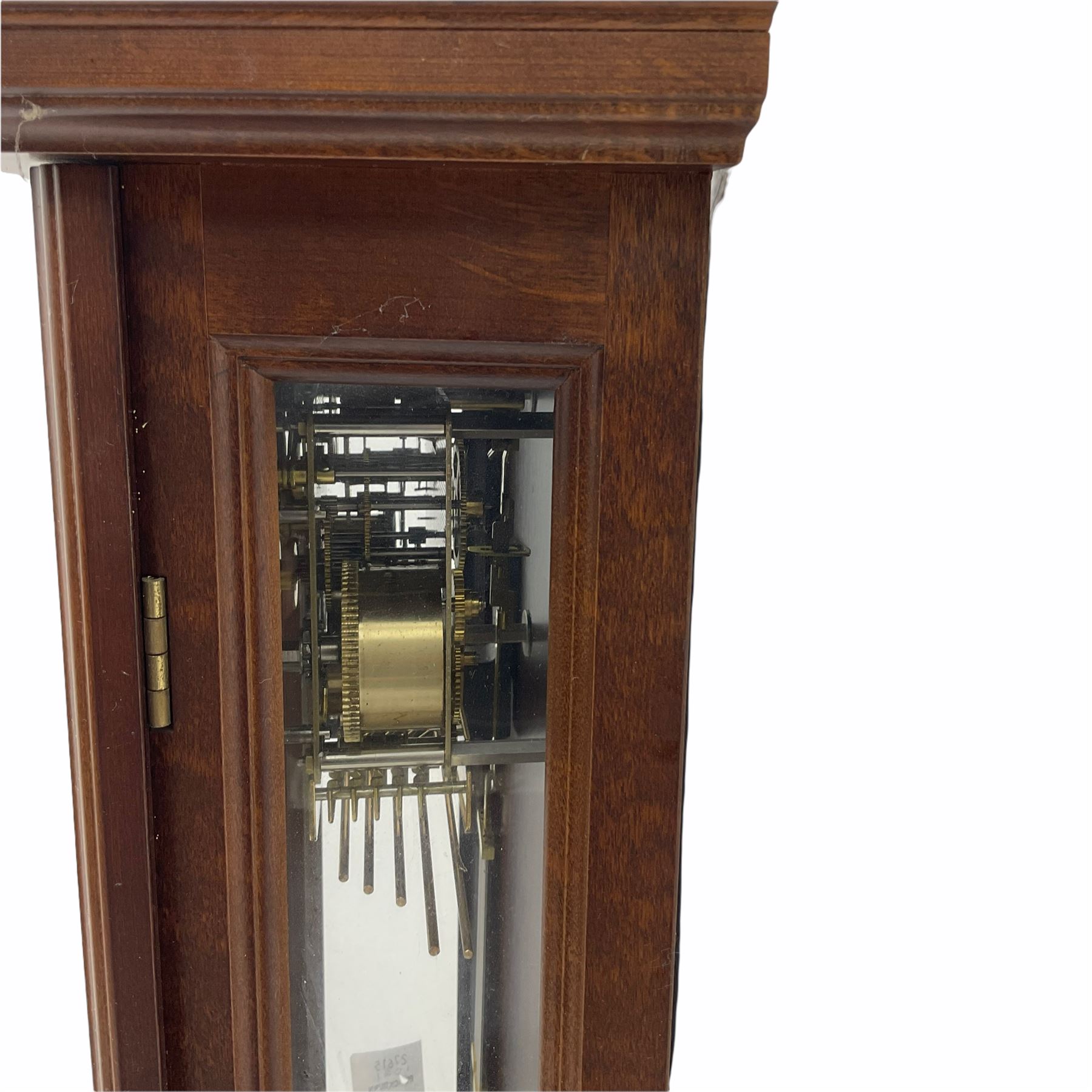 A 20th century  Westminster chime, spring driven three train “William Widdop” wall clock with a visible gridiron pendulum, chiming the hours and quarters on horizontal gong rods, white two-piece dial with roman numerals and minute track, steel spade hands, wooden case with full length glazed door and curved pediment with moulded cornice.
With key.
 
With a 20th century Westminster chime three train mantle clock with Hermle (German)  balance wheel movement chiming on four gong rods, ornate dial with Arabic numerals and minute track, contrasting black pierced steel hands, strike/silent lever.
H23cm W35cm D15cm