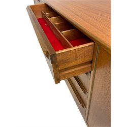 Tom Robertson for AH McIntosh & Co of Kirkaldy - mid-20th century teak sideboard, fitted with four central drawers, flanked by cupboard enclosing shelves and sliding tray, raised on cylindrical supports