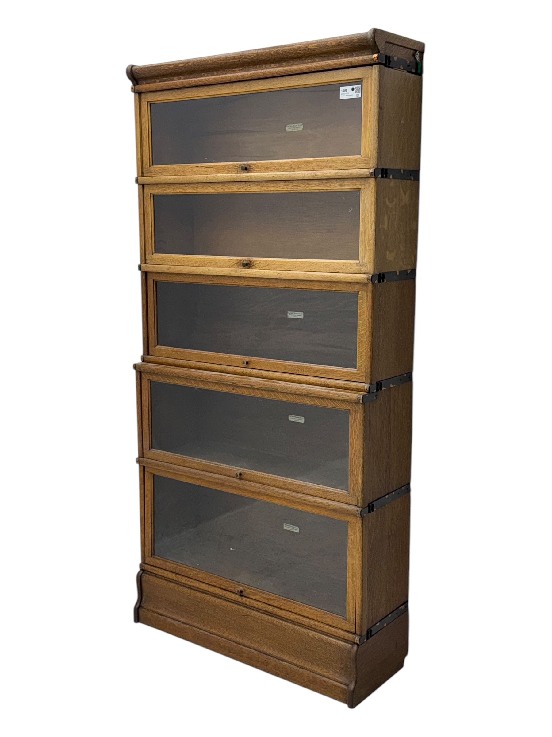 The Globe Wernicke Co. Ltd. - early 20th century oak five-tier stacking library bookcase, each section enclosed by hinged and sliding glazed door, on shaped plinth base 
