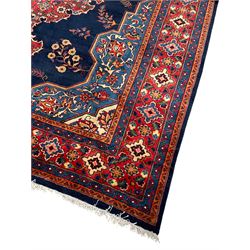 Persian Veis indigo ground carpet, the field with large pole medallion decorated with Herati motifs and surrounded by floral sprays, crimson ground border with repeating cross motifs and stylised flower heads, within guard stripes 