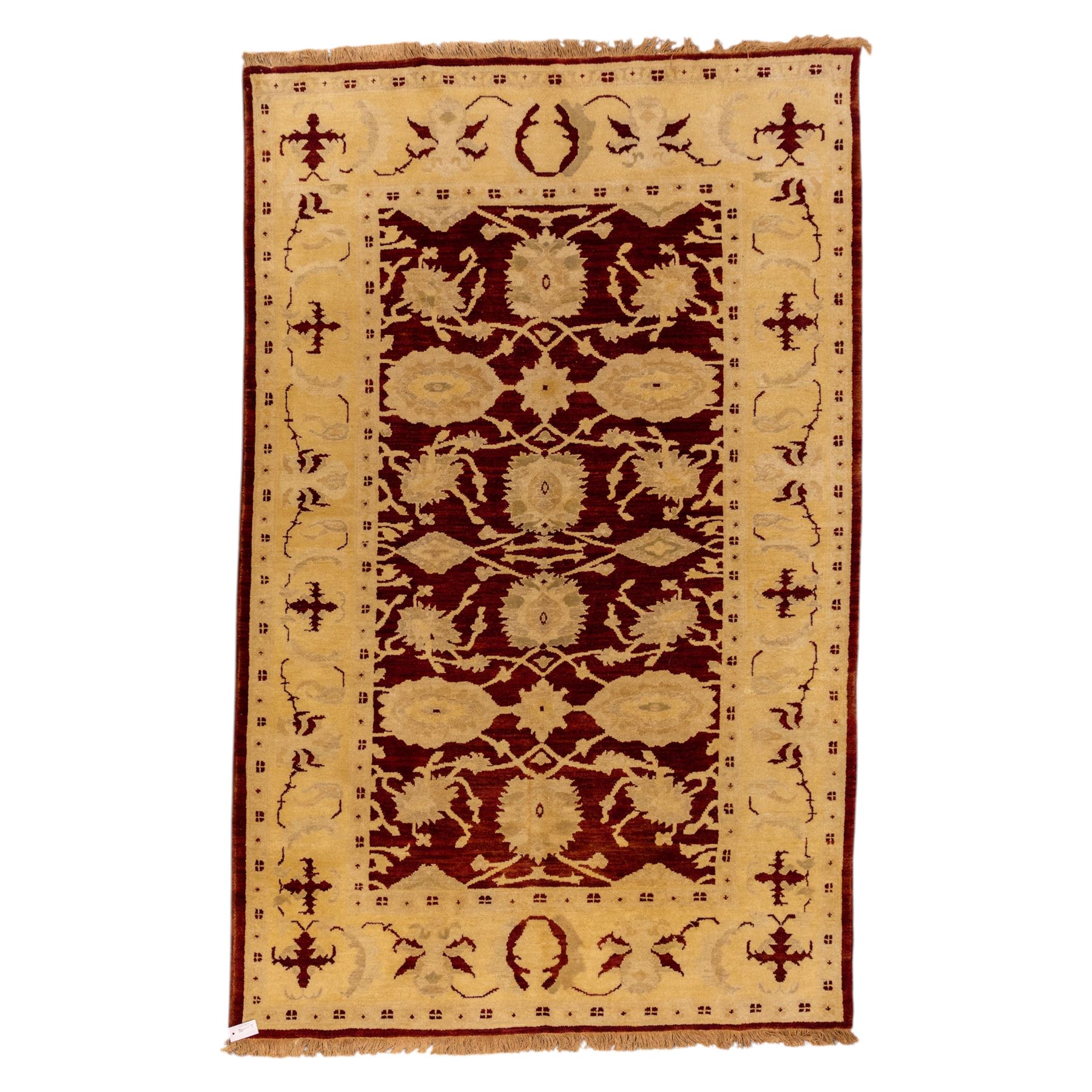 Ziegler design hand knotted wool rug, the rich red ground woven with oversized floral medallions and angular vine scrolls, framed by a contrasting ivory border of repeating floral ornament and minor guard stripes, with fringed ends