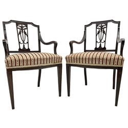Edwardian mahogany framed three-piece salon suite - two-seat sofa, stepped cresting rail over acanthus and scroll carved pierced splat, upholstered in striped fabric (W124cm, H87cm, D62cm); and a pair of matching armchairs (W60cm) 