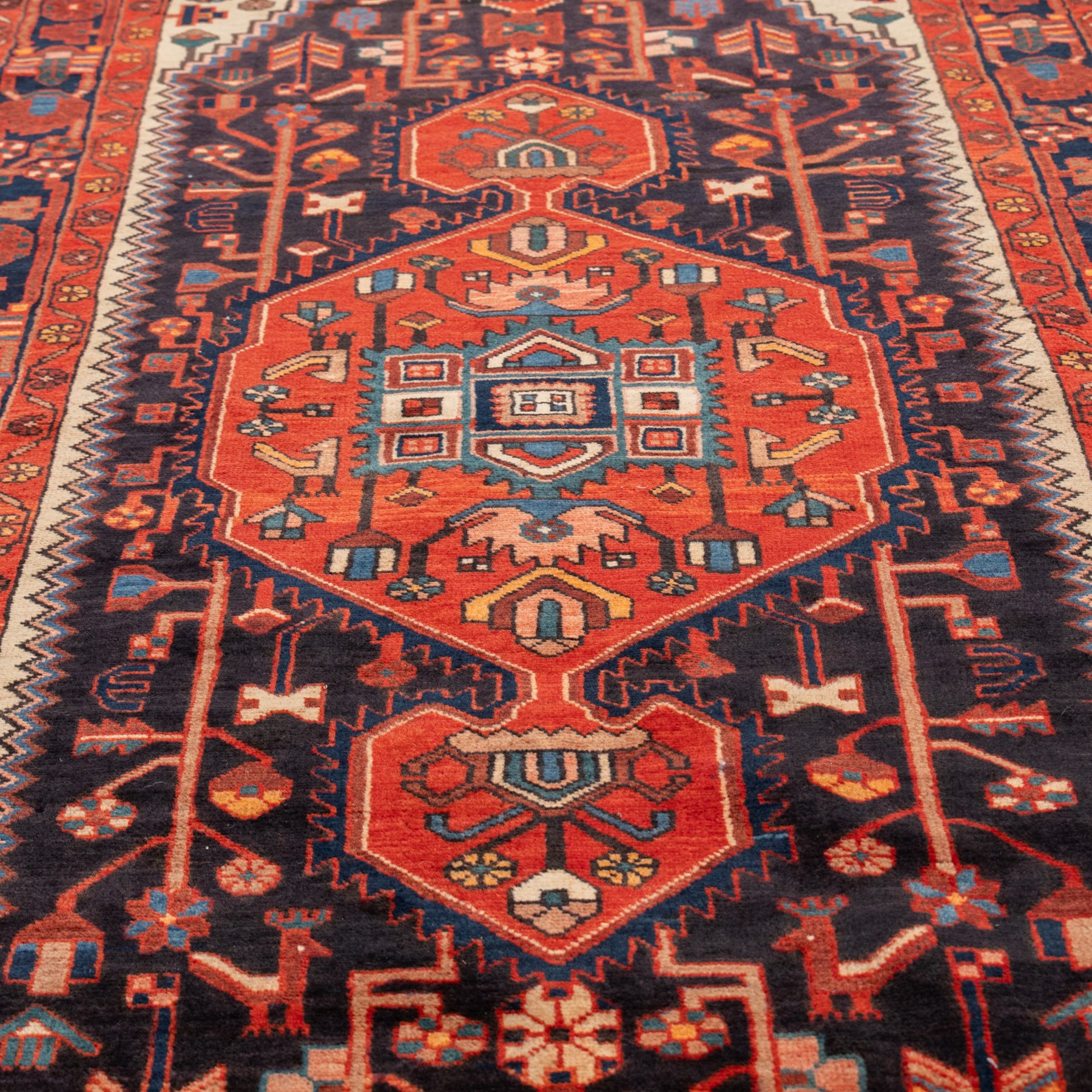 North West Persian runner, the indigo field centred by a red elongated hexagonal medallion with pendant motifs, surrounded by angular flowering stems, ivory stepped floral spandrels, enclosed by an indigo palmette border and red floral guard bands