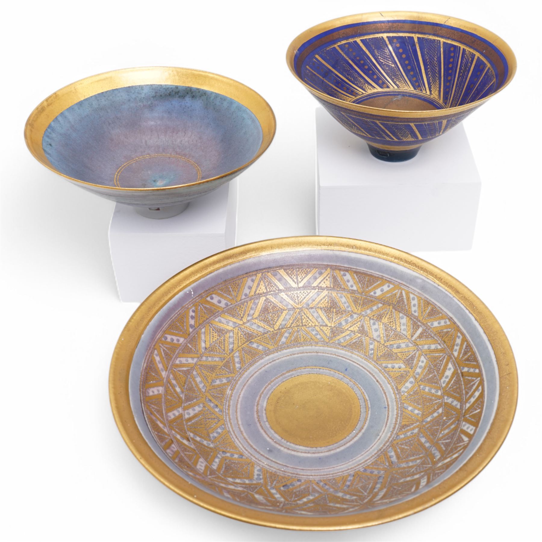 Mary Rich (1940-2022); three studio pottery footed bowls, in blue with gilt geometric decoration, impressed potters seal to base, largest D28cm (3)