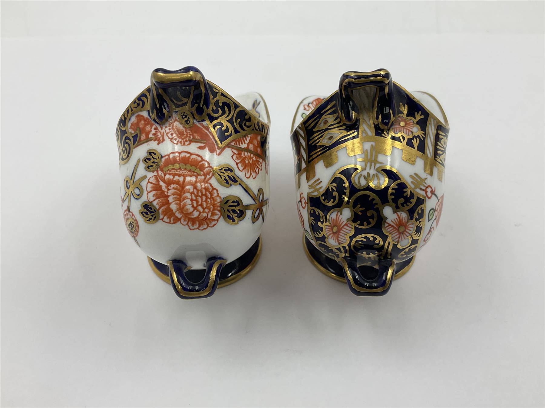 Group of Crown Derby and Royal Crown Derby Imari pattern miniatures, including mid 19th century Stevenson and Hancock cauldron, with painted mark beneath, H5.5cm, a near pair of early Royal Crown Derby scuttles, decorated in the 6299 pattern, each with printed and painted marks beneath including illustration date codes for 1913 and 1922, tallest 6.5cm, and a further early 20th century Royal Crown Derby scuttle, decorated in the 6299 pattern, with printed and painted marks beneath including illustration date code for 1922, H5.5cm, (4)

