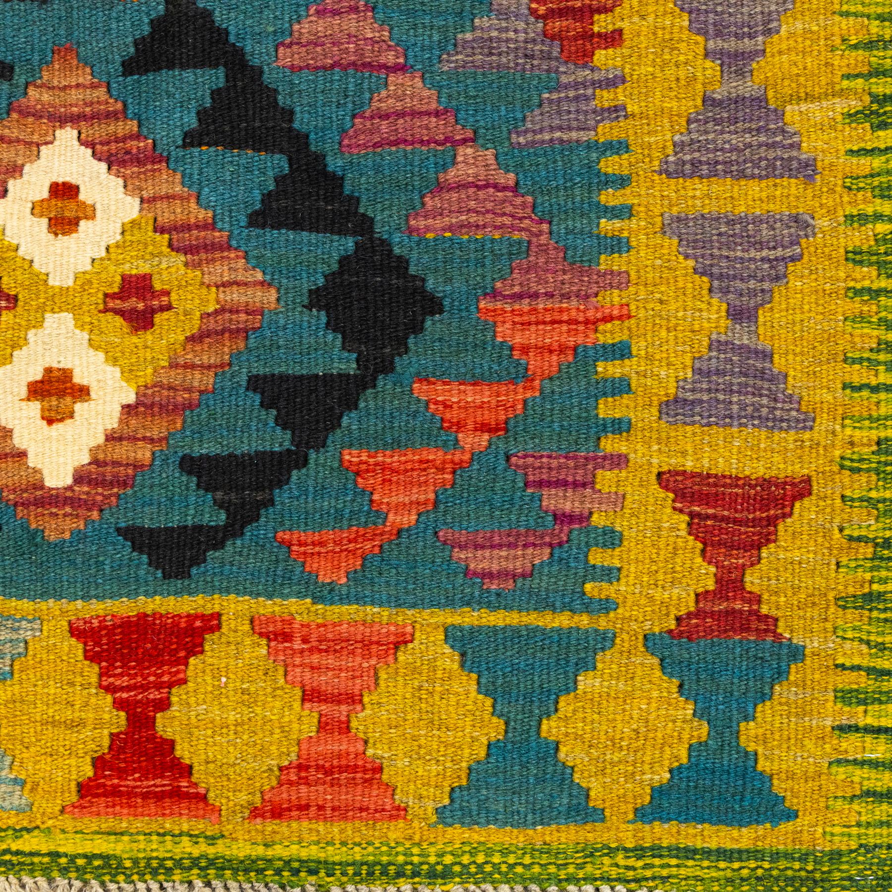 Maimana kilim flatweave runner, central field features a large bold nested diamond motif and stylized geometric lozenge patterns on olive purple, blue, and green tone ground, border stripe in teal ground, and fringe