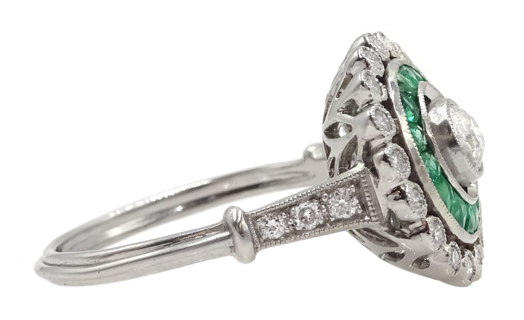 Platinum round diamond and calibre cut emerald target design ring, with diamond set shoulders