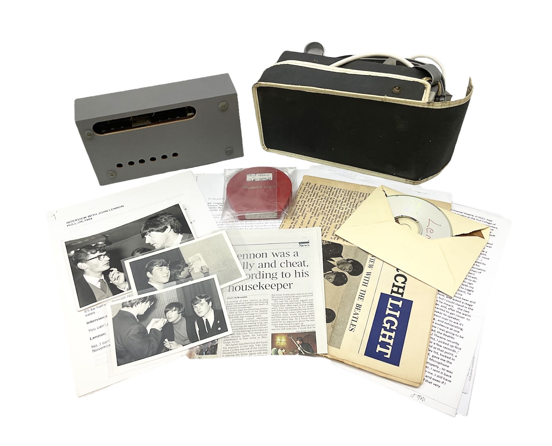 John Lennon interview recording conducted by John Hill student of Hull University on the 16th October 1964 at the A.B.C. Theatre Hull on behalf of the university newspaper 'Torchlight'. The interview lasts eight and a half minutes. It catches John in an upbeat breezy mood answering questions about the following topics: the song writing process ('sometimes you get an idea ....I dunno....my left leg.... and then write about that....'), recording (.... 'they just say - you're recording on such and such a date and they hope we turn up with some good songs written ....'), an alternative career path (.... 'I'd probably just have been a lay-about....'), failing at college (....'some other lads did my exams for me ....'), reading matter ( Clockwork Orange, Alice in Wonderland), his books of prose, tastes in music, the Blues, The Rolling Stones, being a Beatle vis-a-vis anonymity ('Whatever I'd be I'd choose to be rich .... who wants to walk down the street?').
The interview was recorded on 1/4 inch Emitape on a Fi-Cord Fidelity Recording machine. The reel-to-reel tape comes in its original Emitape plastic box and is accompanied by the Fi-Cord reel-to-reel machine on which the interview was originally recorded. Also included in this lot are a copy of the 'Torchlight' newspaper from 21st November 1964, two photographs of the interviewer with John Lennon (the interviewer is pictured to the left of John Lennon in the photograph in which John is signing a sketch) and one photograph of Paul McCartney with another reporter, the largest measures 12 x 16.5cm and a transcript of the interview. The recording is also accompanied by the original Fi-Cord tape recorder with microphone, four original 2v batteries and battery charger. The tape recorder has been adapted to take 3xAA batteries and the 2v battery charger is fitted with a standard UK 3-pin AC plug. The interview was recorded in the press room prior to the Beatles concert at the A.B.C. Theatre and is sold with copyright.