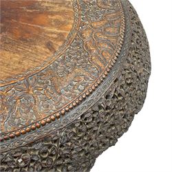 Late 19th century Anglo-Indian carved hardwood occasional table, circular tilt-top carved profusely with mythical animals and foliage decoration, pierced and carved with interlaced leafy branches, leaf carved pedestal supports on a raised platform with further carved and pierced foliage decoration, four carved feet in the form of mythical beasts with gaping jaws 