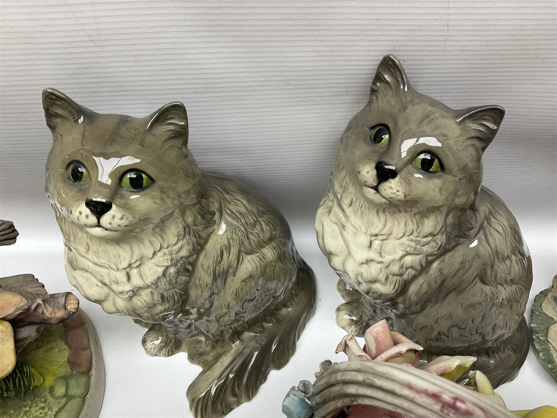 Two Royal Doulton cats, two Capodimonte style figures, and four ceramic baskets of flowers 