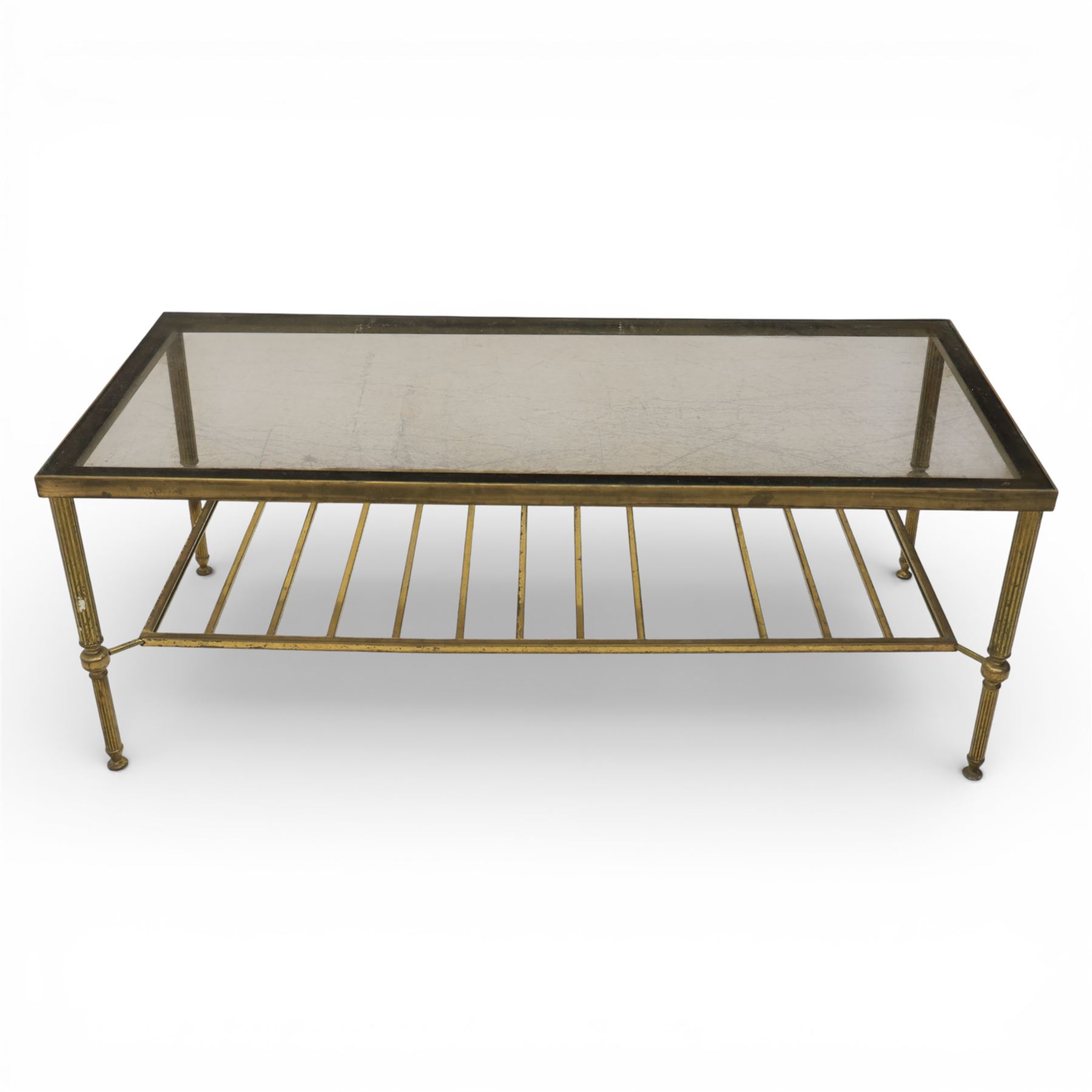 20th century brass and glass topped coffee table, the rectangular glass top within brass frame, upon four reeded legs united by lower slatted under tier 