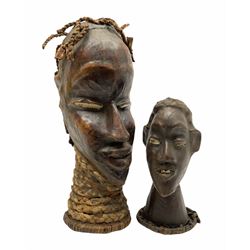 Two carved African heads, comprising one with plaited detail to neck and hair, H38cm, and another smaller example with twisted detail to base