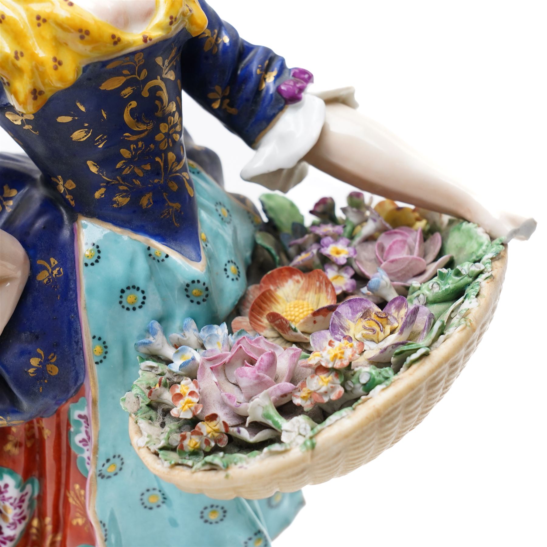 Pair of 19th century Samson of Paris figures of male and female itinerant milliners, each holding a basket with ribbons and flowers on rococo style gilt bases H33cm