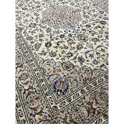 Persian Kashan ivory ground carpet, decorated all-over with interlacing foliate and stylised plant motifs, central scrolling medallion and matching spandrels, the guarded border decorated with repeating palmettes