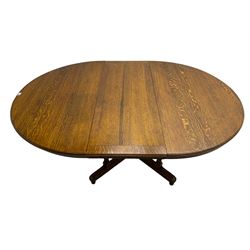 Early 20th century oak dining table, circular extending top with telescopic action, on four pillar base with x-framed platform, turned feet