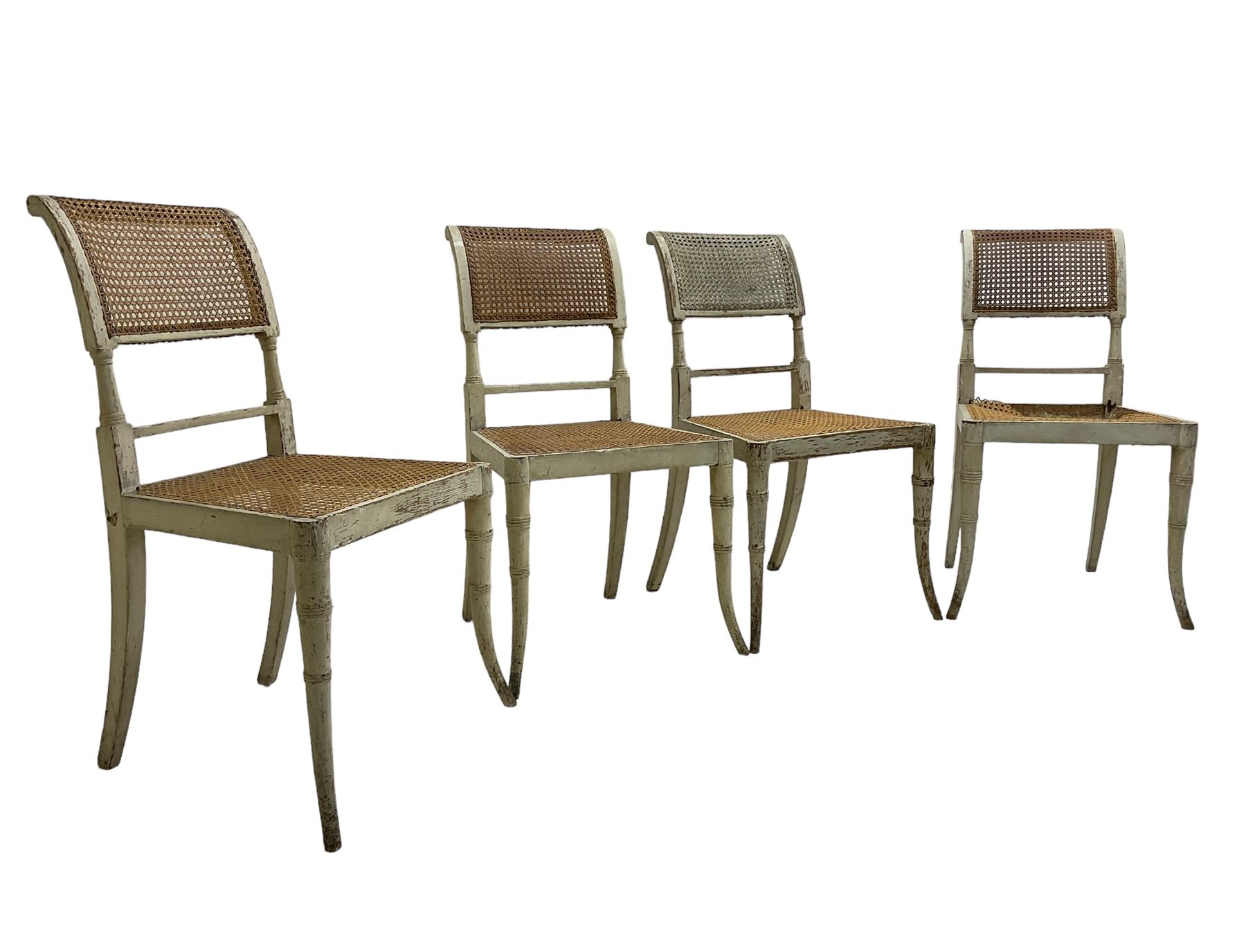 Collection of Regency dining chairs - set of four Regency painted beech dining chairs, with cane seat and back, on collar turned supports with splayed feet (W46cm, H84cm); a pair of Regency ebonised dining chairs (W47cm, H77cm); and a single Regency dining chair, the cresting rail painted with floral cornucopias and central putto vignette, X-frame back over cane seat, on collar turned front supports painted with foliage (W46cm, H84cm) (7)