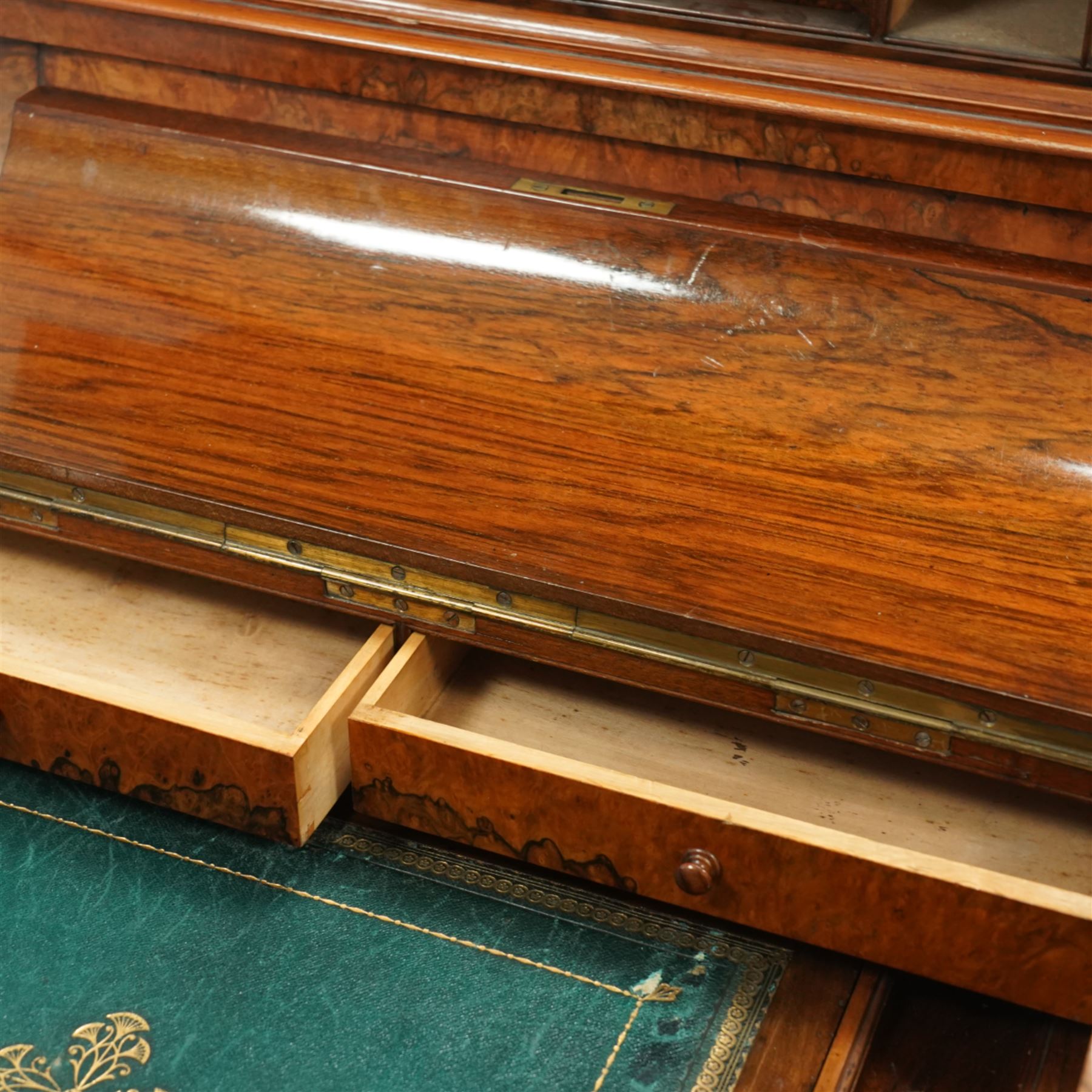 Victorian figured walnut piano top Davenport desk, hidden compartment lifting to reveal small drawers and pigeonholes, the piano lid enclosing drawers and sliding top with hinged leather writing surface, the right-hand side fitted with four drawers, on compressed bun feet 