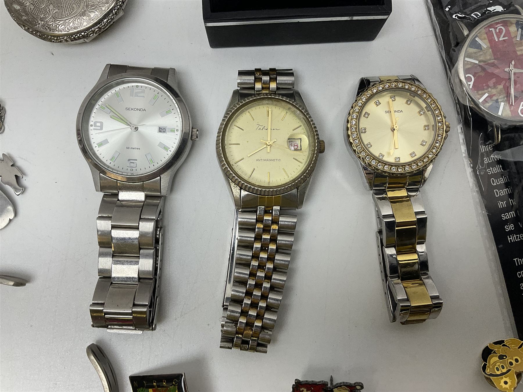 Three Sekonda wristwatches, together with other wristwatches, enamel badges and collectable badges