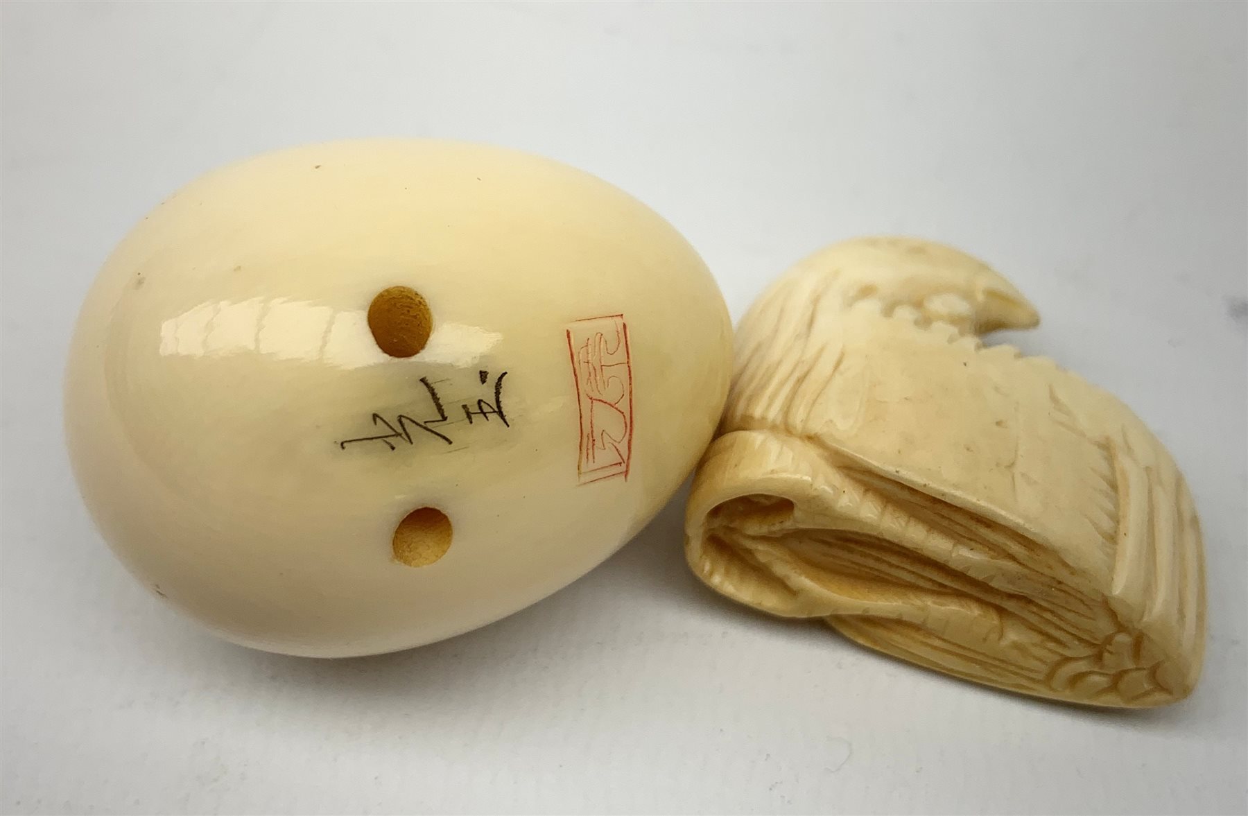A Japanese ivory netsky modelled as a chick hatching from an egg, with marks beneath, together with a further netsky modelled as a seated chicken, also marked, a carved ivory cheroot holder, and two small carved ivory elephants, plus a Japanese stand modelled in the form of a crane, with character marks to base, a Japanese bamboo detailed teapot, cloisonne circular  pot, and an embroidered pouch and purse. 
