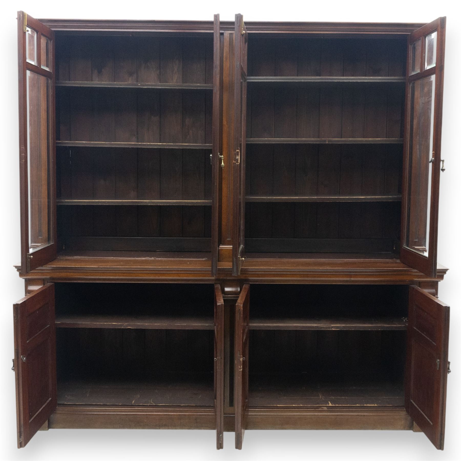 Late 19th century walnut library bookcase, fitted with four display doors with astragal bevelled panes, raised upon a four cupboard base with fielded panel doors