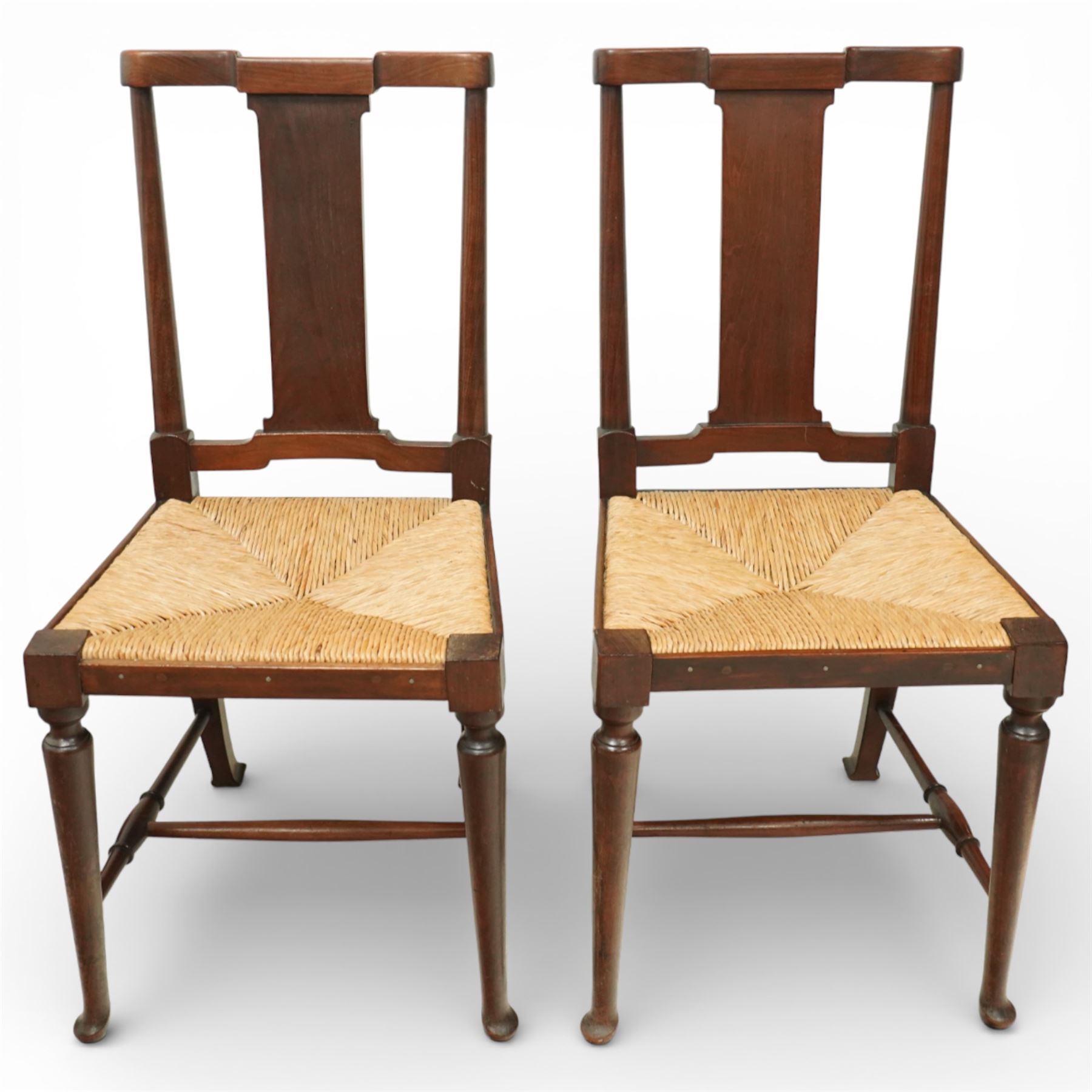 Pair of Morris & Co ‘Hampton’ design chair attributed to H. Howes, the shaped rectangular back with central splat over a rushed seat, on turned supports united by stretchers