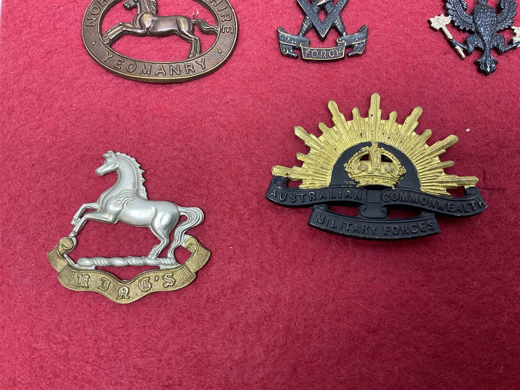 Forty glengarry and cap badges and shoulder titles including Gordon Highlanders, Canada and Canadian Field Artillery, New Zealand Field Artillery and Rifle Regiment, Shropshire Light Infantry, 14th/20th Kings Hussars, 17th Lancers, Northamptonshire Yeomanry, Royal Lincolnshire, Special Air Service, 19th Alexandra P.W.O. Hussars etc; mounted on two boards for display (2)