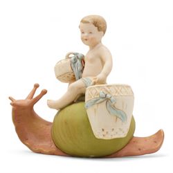 Royal Dux figural posey holder, modelled as a boy with baskets riding a snail, H16.5cm