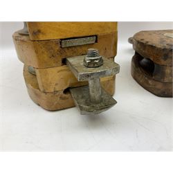 Three ship pulleys comprising wooden block double with swivel eye marked 'wooden block 240mm double rope: 22mm',  wooden block double with upset shackle and wooden block with stiff swivel hook, largest example L50cm