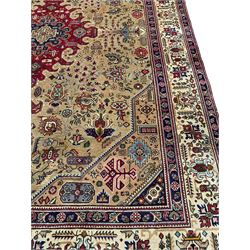 Persian Azarbaijan golden ground carpet, the shaped crimson ground medallion decorated with geometric motifs, the field profusely decorated with stylised plant and flower head motifs, repeating border with guard bands 
