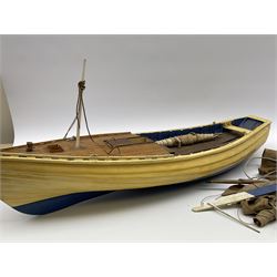 Early 20th century cream and blue painted wooden model of a Whitby coble, the planked upper deck with access hatch to a fitted motor, simulated planked mahogany lower deck with inspection hatch for propeller shaft, various masts and sails and detachable external rudder L70cm. Auctioneer's note: From the Walker family of Sandsend