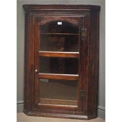  George III mahogany wall hanging corner cabinet, projecting cornice, arched glazed door enclosing four shelves and three small drawers, W78cm, H112cm, D46cm  
