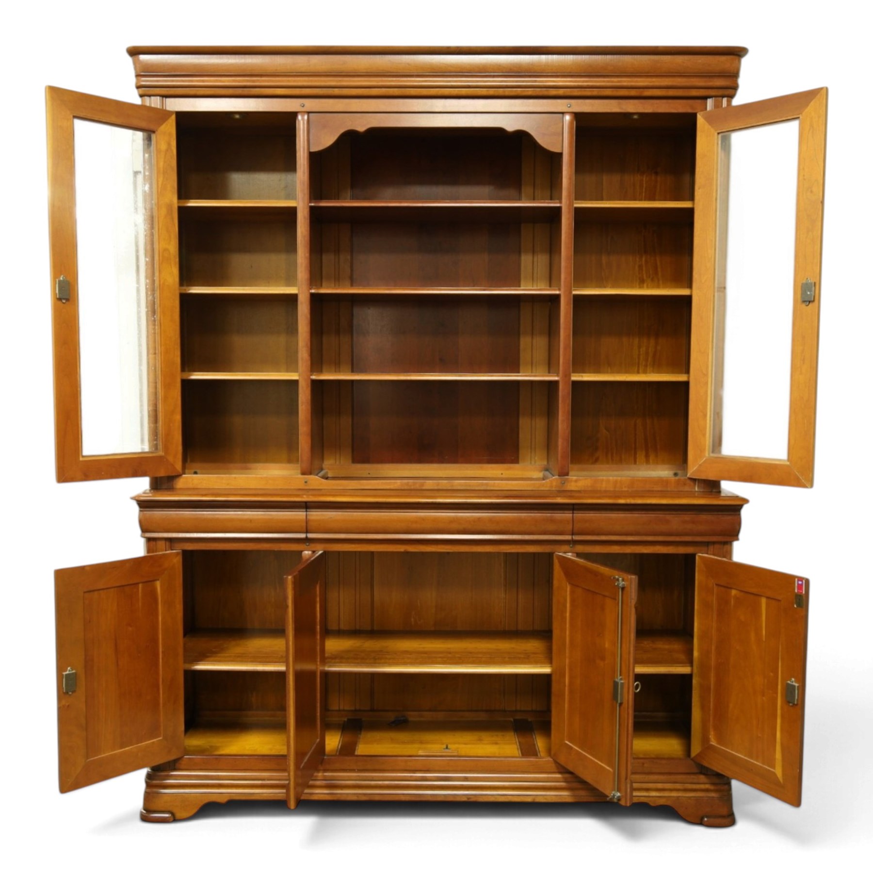 Barker & Stonehouse - large cherrywood bookcase cabinet, the moulded cornice above two glazed doors flanking an open central section, the base with three cushion drawers over four lockable panelled cupboard doors, raised on bracket feet