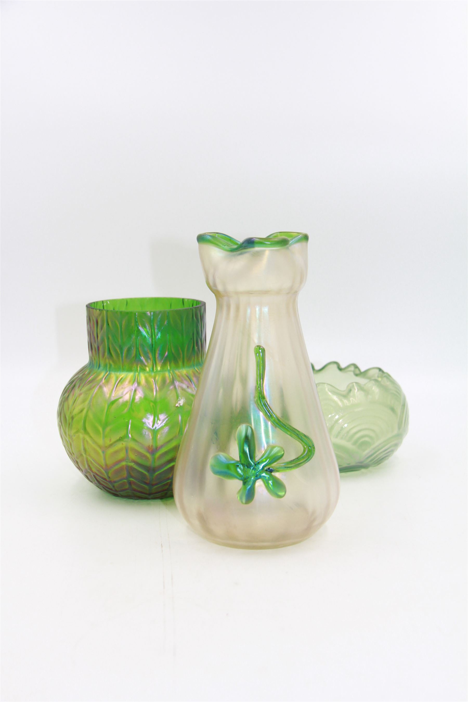 Three Austrian Art Nouveau iridescent glass vases, including a Kralik example of tapering form, with pearlescent lustre body and applied green flower decoration, tallest H18cm
