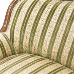 Victorian walnut framed salon sofa, the shaped back and scroll arms with carved floral detail, upholstered in green and cream striped fabric, raised on scrolled cabriole legs 