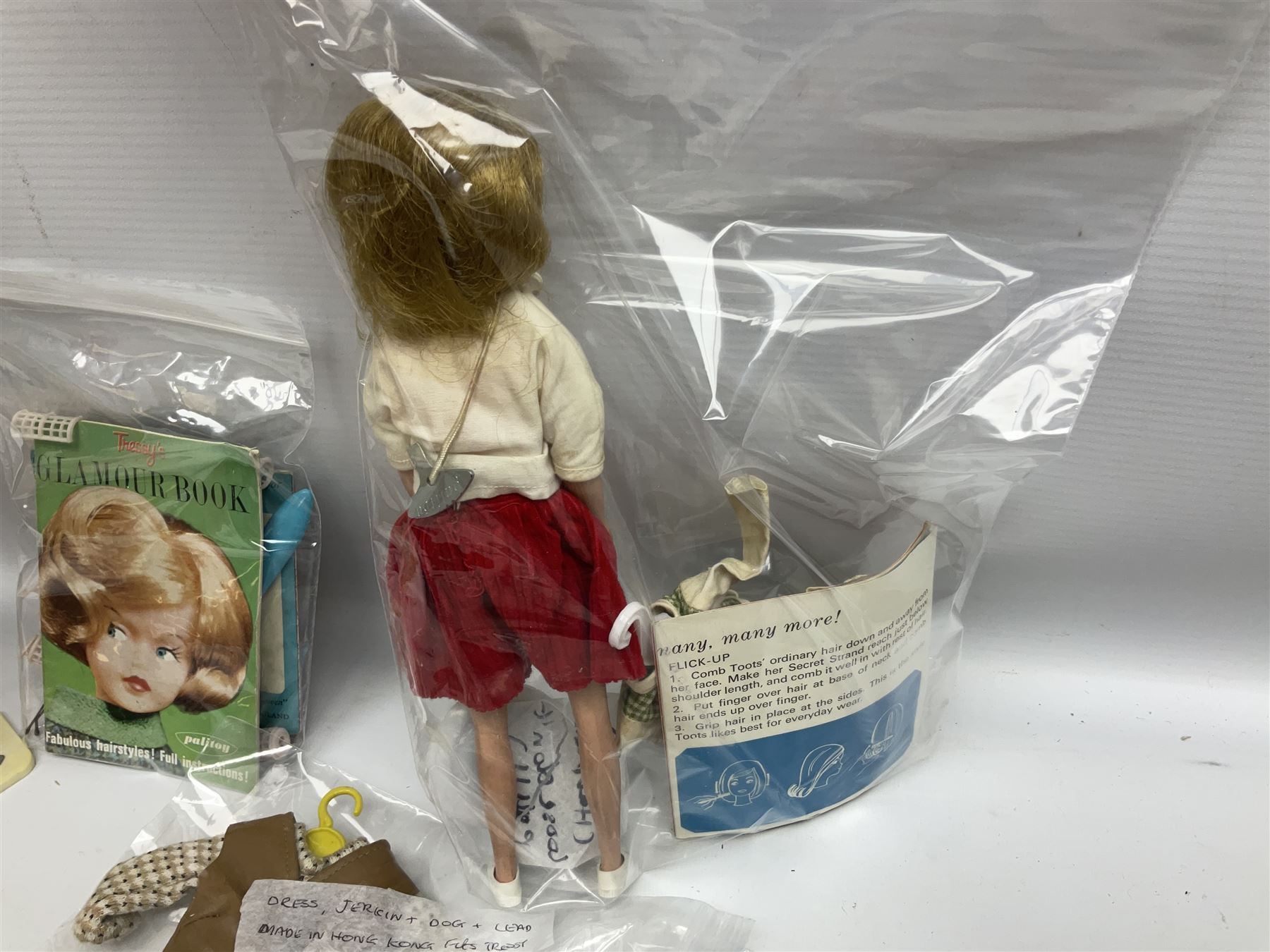 1960s Palitoy Tressy fashion doll, boxed with stand and booklets; four additional Tressy outfits (In The Office, Winter Journey, Winter Sports and Evening Date); two other outfits; and Tressy's Little Sister Toots doll with Style Book and additional outfit