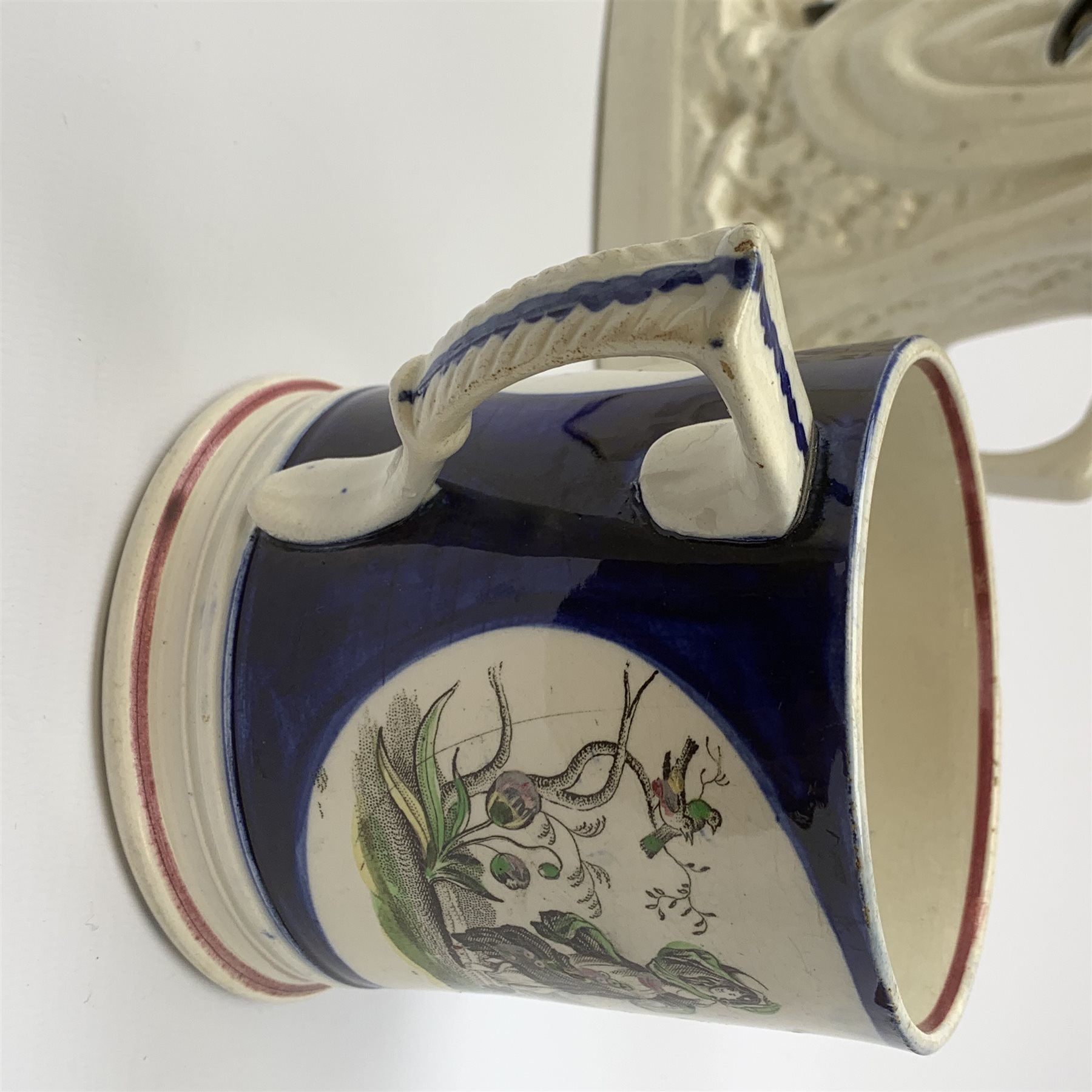 An early Victorian earthenware frog or surprise mug, decorated with printed and overpainted figural panels, H11cm, together with a 19th century child's plate detailed with a figural scene and inscribed Father Matthew administering the total abstinence pledge, 17.5cm, and a Staffordshire flat back figure seated upon a horse, H33cm. 